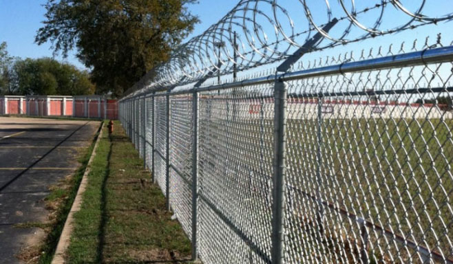 Razor barbed wire mounted on chain link fence.